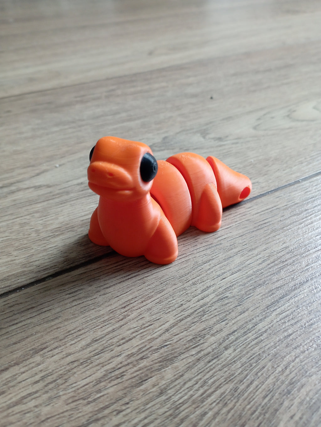 Flexi dinozaur w kolorze pomarańczowym i czarnym