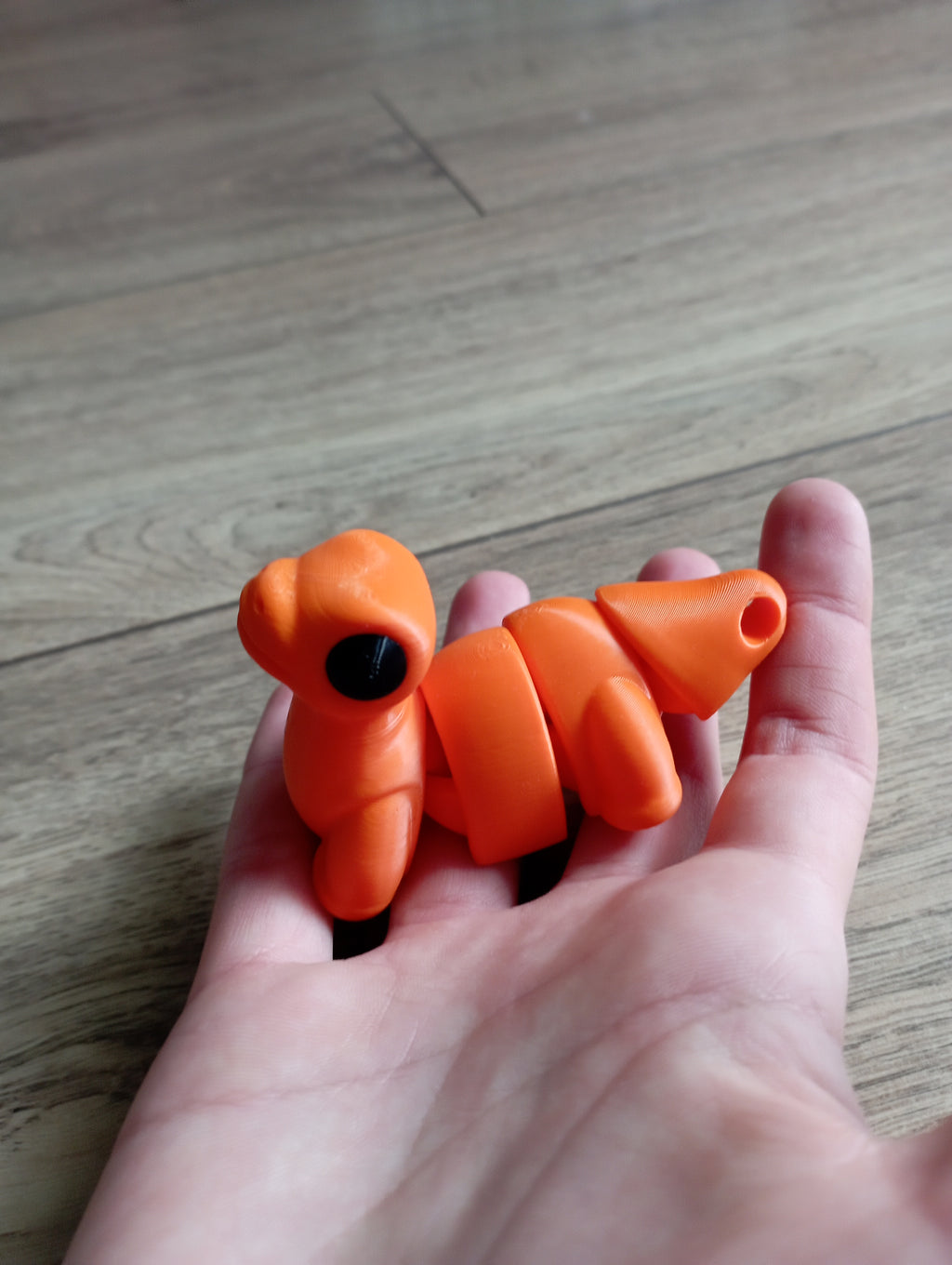 Flexi dinozaur w kolorze pomarańczowym i czarnym