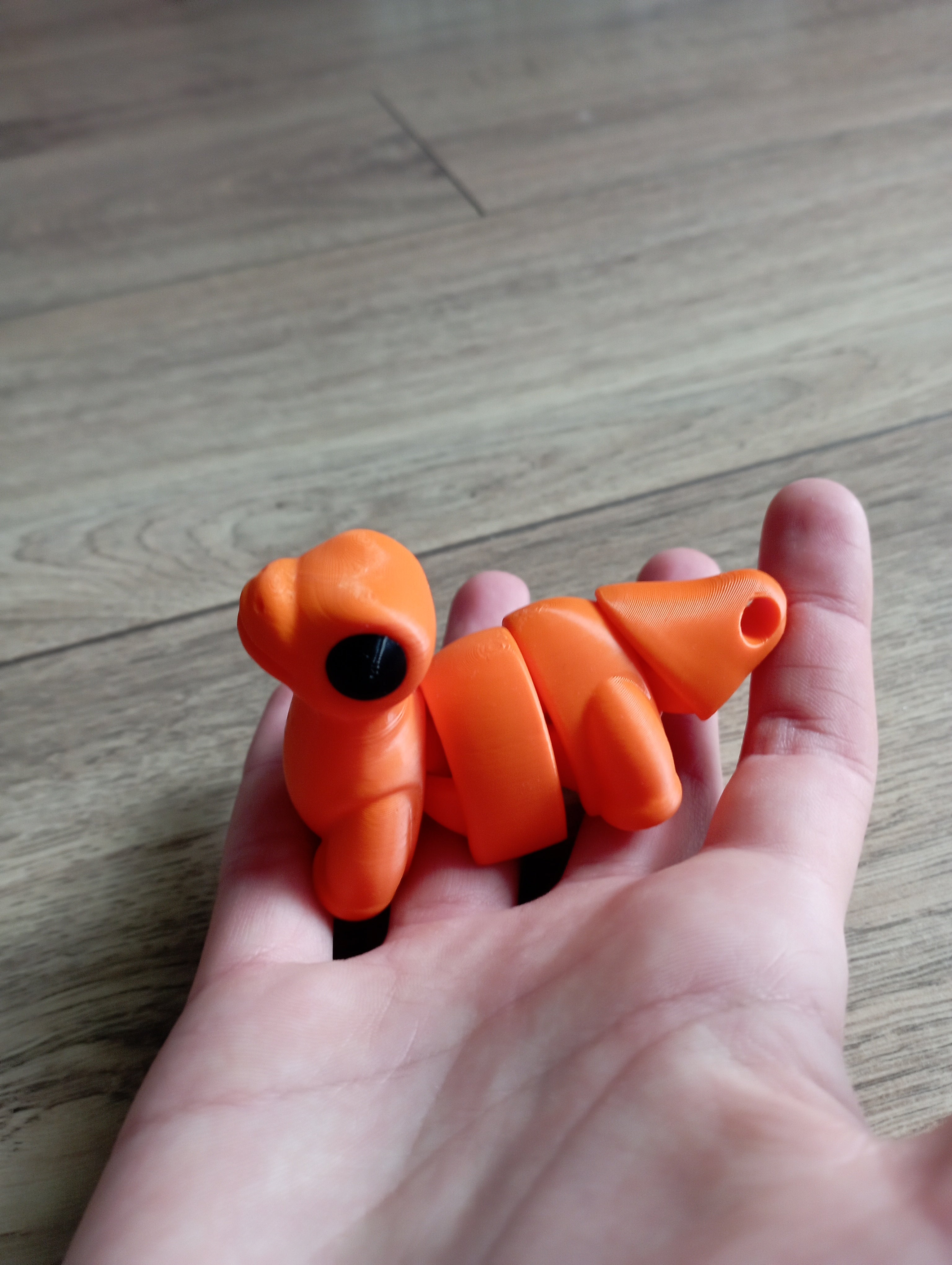 Flexi dinozaur w kolorze pomarańczowym i czarnym