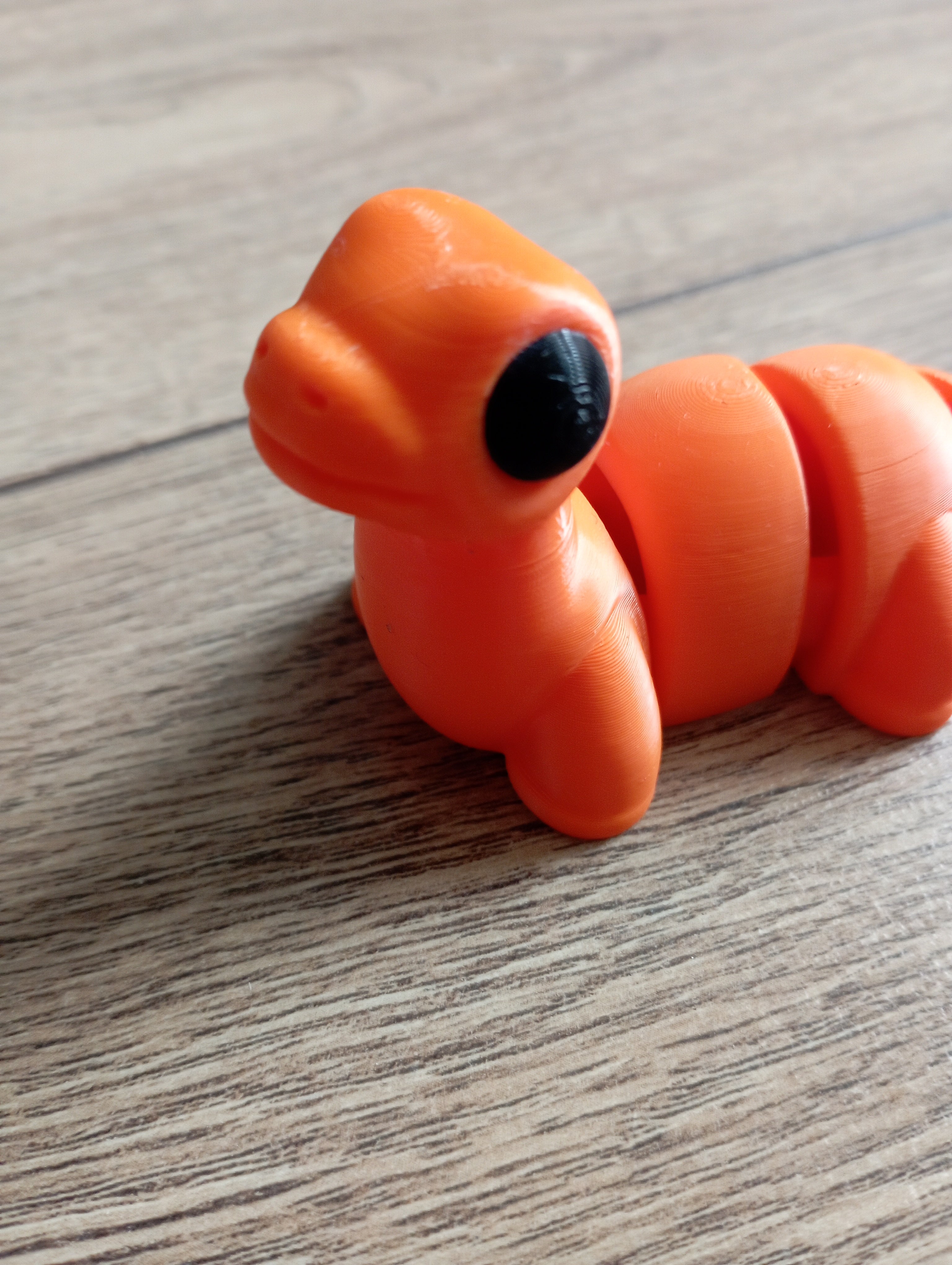 Flexi dinozaur w kolorze pomarańczowym i czarnym