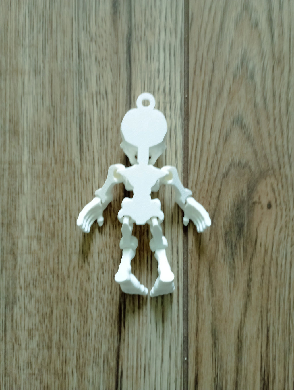 Brelok ruchomy kościo trupek w kolorze białym.