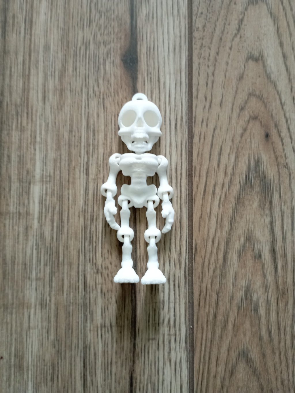 Brelok ruchomy kościo trupek w kolorze białym.